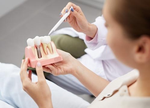A woman being shown an illustration of a permanent Dental Implants in Pampa, TX